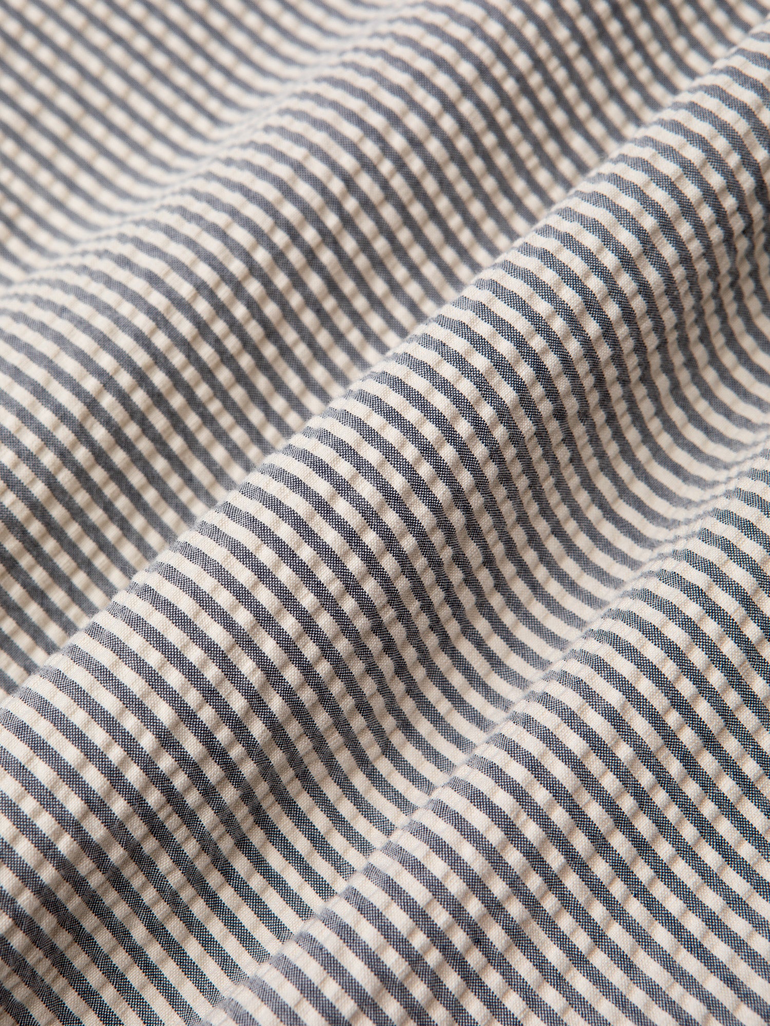 A classic stripe seersucker fabric, used to make shirts and trousers by menswear brand KESTIN.